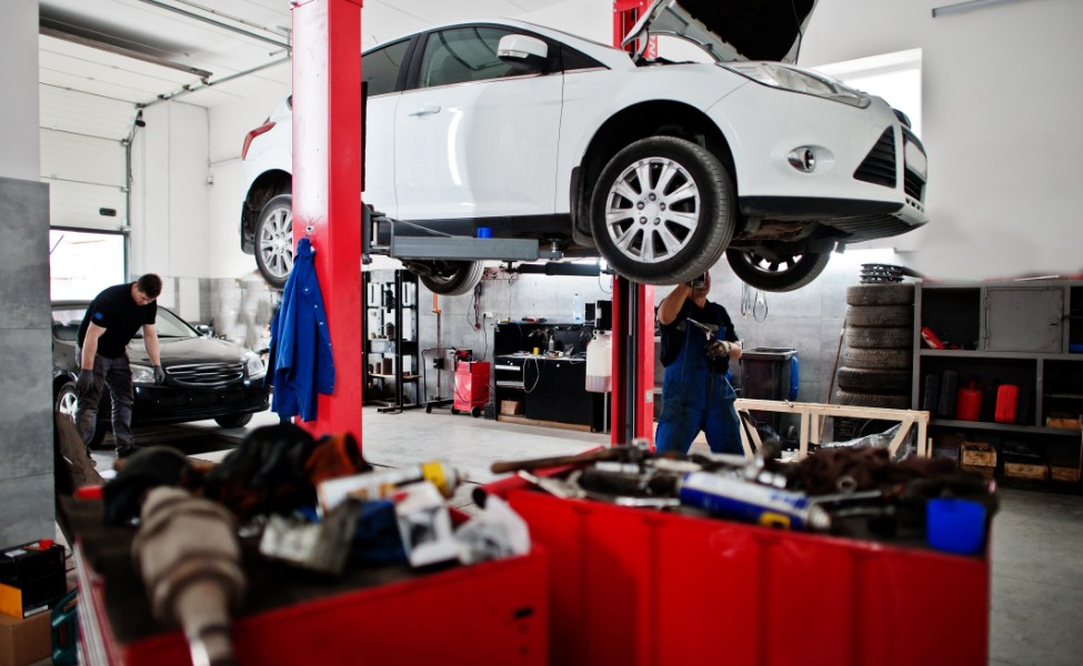 sebuah mobil sedan putih sedang diservice